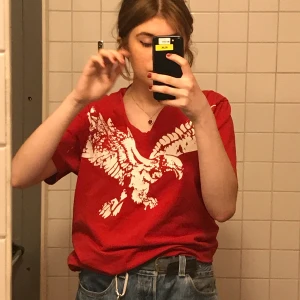 Cool röd tisha  - röd v ringad tröja med en örn på! Frakt 42 kr