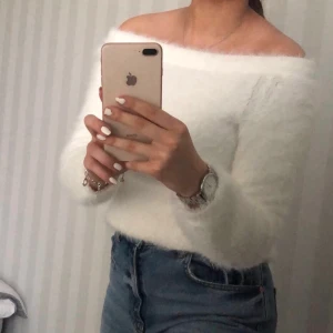 Fluffig vit offshoulder tröja - En vit fluffig offshoulder tröja från Ginatricot som framhäver nyckelbenen superfin! Jättesöt topp som klär upp en vanlig outfit! Köparen står för frakten eller hämtar i Motala :)