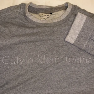 Calvin Klein sweater - Grå sweater från Calvin Klein köpt på Emmaus i Malmö. Mudd i ärmarna och nertill. Bra skick🤍 Strl M men mer som M/S