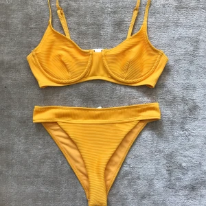 Oanvänd gul bikini - Det står ingen storlek i bikinin men passar perfekt för mig som har storlek S. Den är aldrig använd och så otroligt fin. Den är ribbad i modellen!