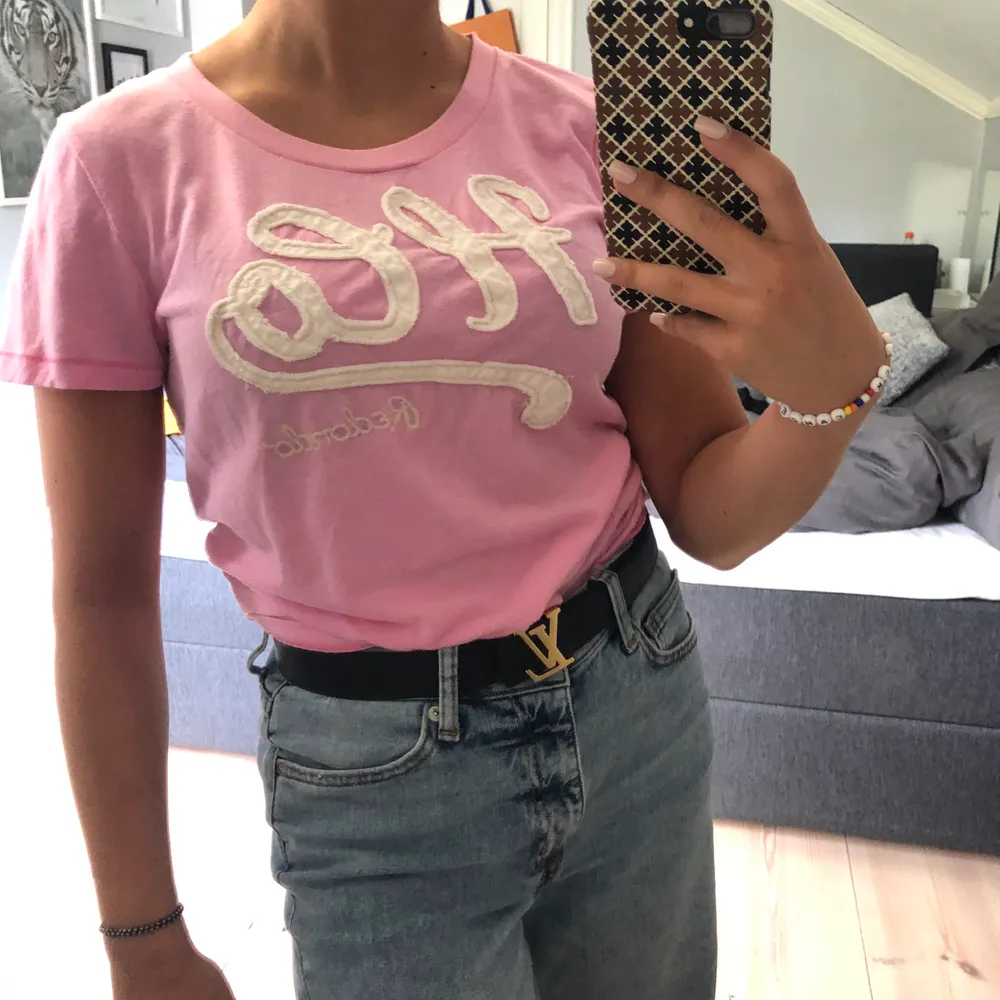 Rosa hollister t-shirt med nån konstig text jag inte kan tyda haha, FRAKT INGÅR I PRISET, kontakta för fler bilder eller frågor, buda gärna. T-shirts.