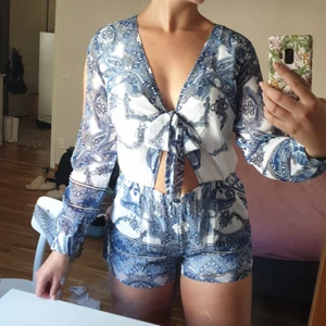 Jumpsuit - Somrig jumpsuit från bikbok. Använd 1 gång så den är i nyskick! Man knyter i fram så man kan välja hur urringat man vill ha det och så har den öppna ärmar