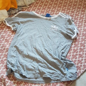 Grå adidas t-shirt säljes - Grå adidas t-shirt säljes då den sällan blir använd! Superfin och superskön!! Passar till det mesta!