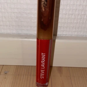 Läppglans - Ett rött läppglans som ej är använd