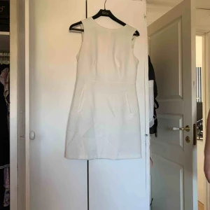  - En vit klänning med dragkedja där bak som är guldig