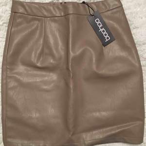 Beige kjol från boohoo i storlek xs/34, aldrig använd och lappen sitter kvar 