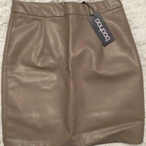  - Beige kjol från boohoo i storlek xs/34, aldrig använd och lappen sitter kvar 
