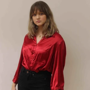  - En exklusiv klarröd silkesskjorta med röda knappar som liknar diamanter