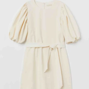  - Superfin slutsåld klänning från HM trend. Gräddvit med puffärmar och bälte. Storlek s.