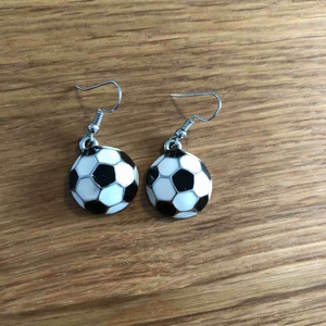  - Fotbolls örhängen, aldrig använt, till tjejer och killar som gillar fotboll, man betalar frakt själv. Som en halv fotboll ser dom ut, svarta vita med silver på. 100% metall. Kom gärna med egna pris