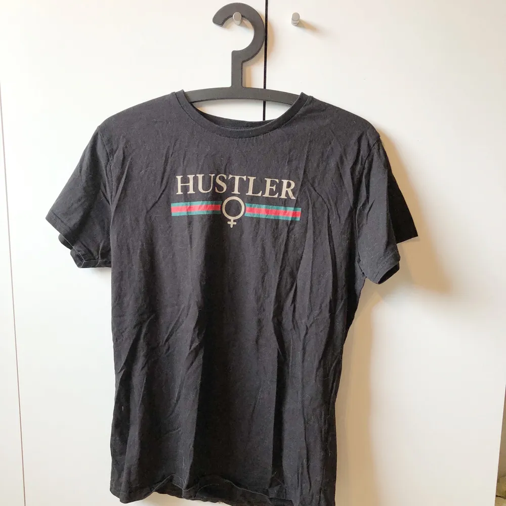 svart t-shirt med texten ”hustler” i gucci stil på bröstet. köpt på madlady för några år sedan och finns ej att beställa på deras sida längre. väldigt bra skick, knappt använd. storlek L men är liten i storleken så sitter mer som en M. T-shirts.