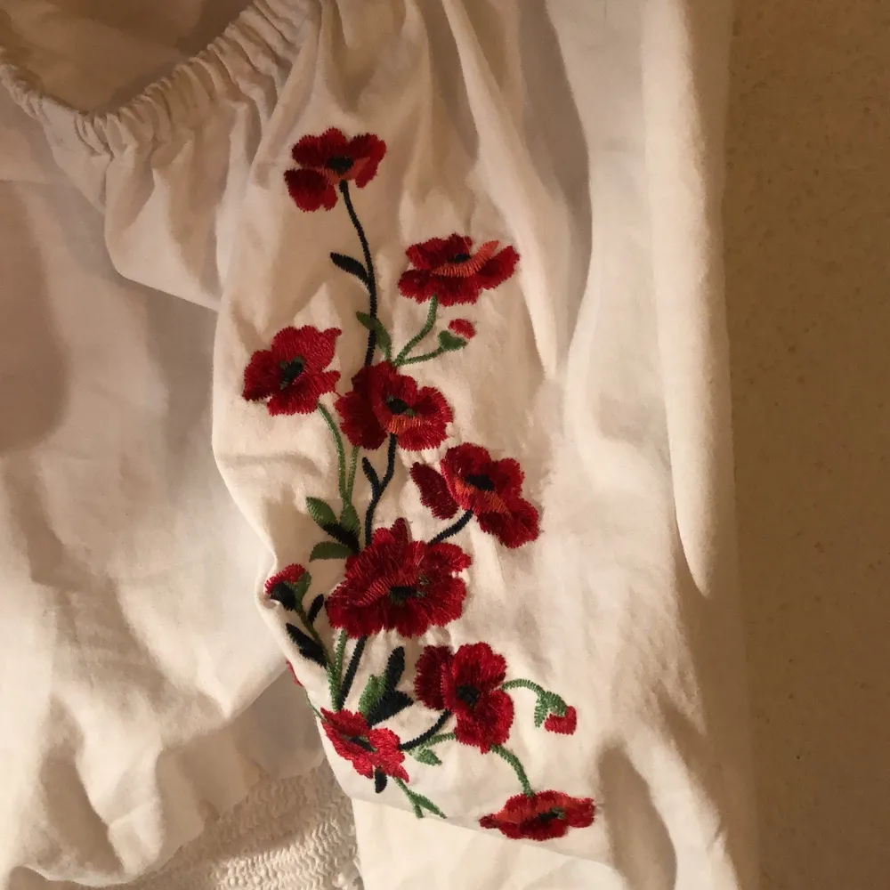 En off-shoulder tröja med rosor sydda på armen. Den har knytningar längst ner på ärmen (skicka om du vill ha bilder:) . Tröjor & Koftor.