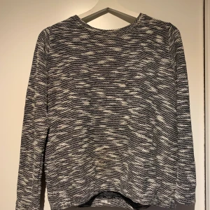 Stickad tröja  - En svart vit och grå stickad tröja, med dragkedja i ryggen, sitter fint och är i bra skick. Priset kan diskuteras, köparen står för frakten 