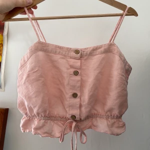 Linne från Urban Outfitters - Gulligt rosa linne från Urban Outfitters i strl S med justerbara axelband. Köpt för 300kr för ett år sen och använt endast en gång. 