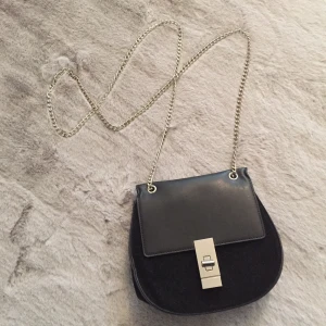 Crossbody/Axelväska - Mått: ca 17x17cm. Svart. Helt ny. Oanvänt 