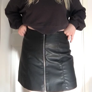 Svart minikjol i fakeskinn - Säljer denhär skitsnygga korta kjolen i fakeläder/fakeskinn från H&M Divided! Endast använd en enda gång så den är i nyskick. Har en dragkedja på mitten som går att öppna hela vägen ner, på mig som är 162cm slutar kjolen precis ovanför knäna. Köparen står för frakten :) Pris kan diskuteras vid en snabb affär! (Nypris: 200kr)