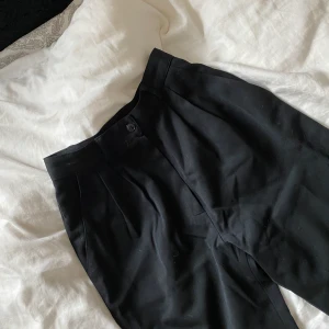 Raka kostymbyxor - Ett par supersnygga raka kostymbyxor ifrån RockIt vintage i London. Dessa är väldigt tajta i midjan så har man svårt att hitta byxor som sitter åt i midjan passar dessa perfekt. De är lite längre än till ankeln på mig som är 161cm och i en rak/wide model