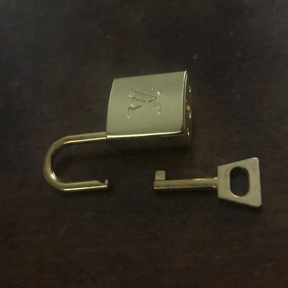 Louis vuitton lås + nyckel, inte äkta men i mycket fint skick och ser äkta ut. Den är guldig. Perfekt att ha som berlock till ett halsband eller på en väska. I mässing.. Accessoarer.