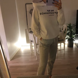 Peak Performance hoodie - Vit peak performance hoodie med svart text. Köpt för ett år sedan, i storlek L från killavdelningen. Men sitter som en M på mig, blir som en oversized på en S. Använd men i fint skick. Först till kvar eller högstbjudande.