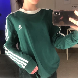 Adidaströja - En mörkgrön adidaströja med vita detaljer 