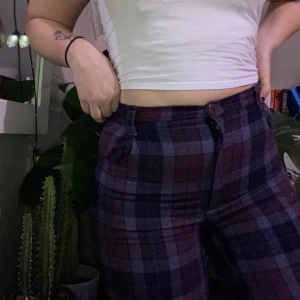 Rutiga byxor - Rutiga lila byxor. Köpte second hand, aldrig använda. Står inget om storlek på byxorna men passar en upp till 36/38. Väldigt figursydd. Frakt tillkommer! 