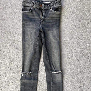 Grå jeans - Ett par tajta gråtvättade jeans me hål på båda knäna och slitningar vid bensluten. Från bikbok, strl xs. Frakt tillkommer💓