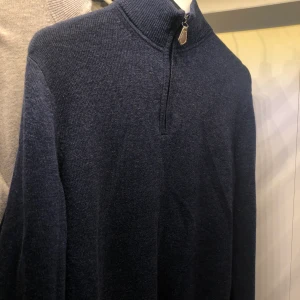 Marinblå Tommy Hilfiger semi-polotröja  - Marinblå polotröja i mellantjockt material. Superskön och inte stickig alls. Den är en M i mansstorlek men jag som tjej som har M har kunnat ha den och så har den en oversize-passform. Hör av dig ifall du vill ha flera bilder och pris går att diskutera!🌟