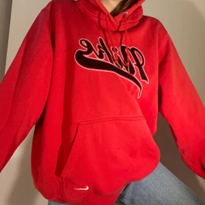 Nike hoodie - Jättefin vintage Nike hoodie i skitcool röd färg. Nike logga på bröstet samt nere vid fickan. Oversize i modellen och passar de flesta storleken beroende på önskad passform. 