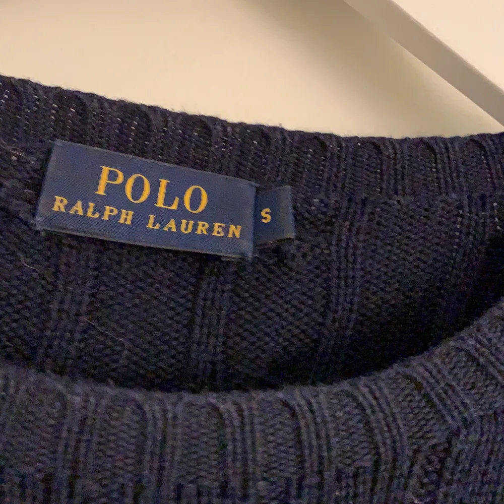En kabelstickad mörkblå sweater från Ralph Lauren. Strl S, använd ett par gånger så i bra skick. Lite smutsig på kragen, men ej tvättad.. Tröjor & Koftor.