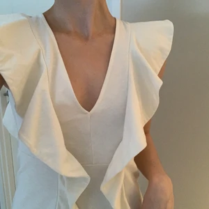 Vit klänning med volanger - Vit klänning med volanger från H&M, öppen rygg, storlek 36, en riktig sommardröm!