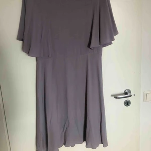  - Jättefin gammel-lila medellång klänning med utsvängda ärmar. Endast använd ett fåtal gånger. Storlek L, jättefin passform. Åtsittande i midjan och på överdelen, sedan utsvängd/fallande kjol