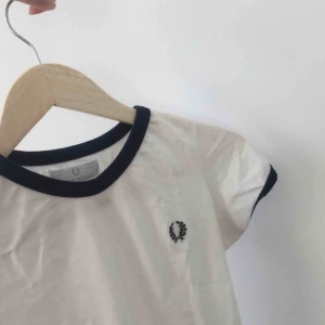 Fred Perry t-shirt - T-shirt från Fred Perry i fint skick! I tröjan står storlek 36 men skulle snarare säga att det är en liten 34. Ganska tight i armarna och kort i passformen.