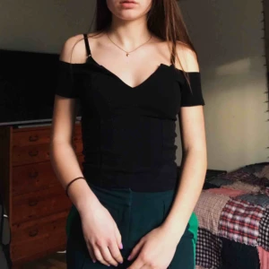 Svart topp - Fin tröja med urringning fram som du kan både klä ner och klä upp. Tröjan är köpt på BikBok men är knappt använd.  Frakt tillkommer