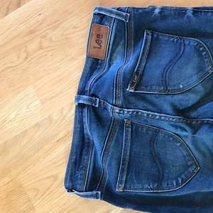 Ett par mörkblå jeans från Lee som använts en del och har någon slitning där bak och något hål på ena knäet. Men de är fortfarande i väldigt fint skick!