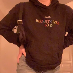 Levi’s hoodie - Svart Levis hoodie med multifärgad text som säger Levistrauss & co. Köparen står för frakten men kan även möta köpare om det är nära :) tröjan har bara används ett fåtal gånger och har inga slitningar eller fläckar                       Bud ligger på 200