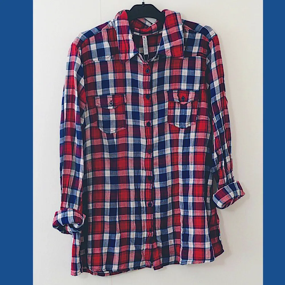 Röd, blå och vitrutig skjorta i oversize-modell. Slutar cirka 10cm från höftbenen. Plagget är från Newyorker och endast använd ett fåtal gånger. Mindre i storlek (XL). . Skjortor.