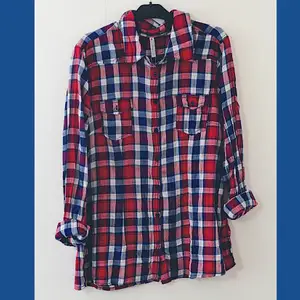 Röd, blå och vitrutig skjorta i oversize-modell. Slutar cirka 10cm från höftbenen. Plagget är från Newyorker och endast använd ett fåtal gånger. Mindre i storlek (XL). 