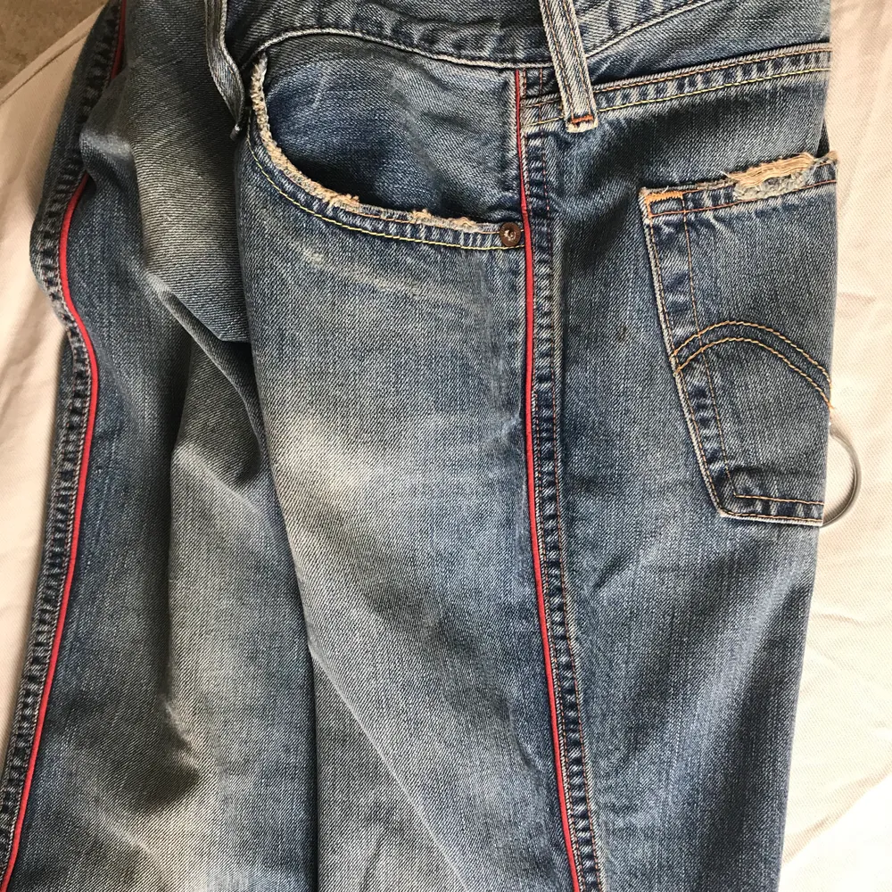 Lågmidjade vintage jeans från Levi’s med röda streck. Rak modell/ lite vidare under låret. Jeans & Byxor.