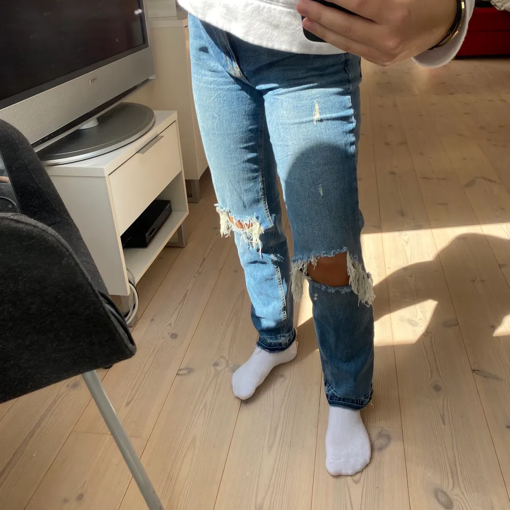 Trendiga jeans med hål i knäna och snygga detaljer längst ner i benen. Slitningar under 2 hankar som syns på sista bilden. Bekväma och stretchiga! Bra passform för lite kortare personer, frakt tillkommer 💕. Jeans & Byxor.
