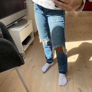Håliga jeans - Trendiga jeans med hål i knäna och snygga detaljer längst ner i benen. Slitningar under 2 hankar som syns på sista bilden. Bekväma och stretchiga! Bra passform för lite kortare personer, frakt tillkommer 💕