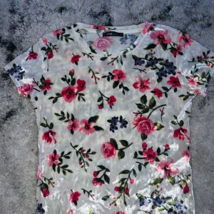 Sammet T-shirt från New yorker - En blommig sammet tshirt från New yorker. Köpte för 169kr och säljer nu för 100kr ink frakt (60kr). Använt runt 3-4 gånger och tycker att den är super skön i materialet. Inga fläckar eller på nått sätt trasig! 