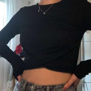 Svart tröja - Tajt svart ribbad tröja från bikbok med ”korsgrej” framtill. Använd max 2 gånger! Betalning sker via swish(köparen står för eventuell frakt eller mötas upp!)💞💞