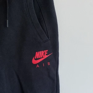 Mjukisbyxor nike - Svarta Nike air-mjukisbyxor med viss cargo-stil. Sköna och snygga. Bra passform. Möts upp i sthlm eller fraktar mot fraktkostnad 🥰