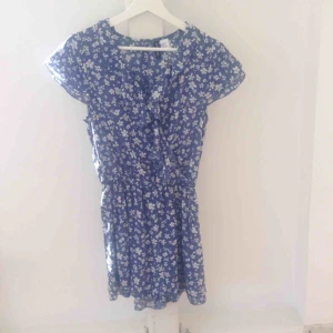  - Byxdress eller jumpsuit från H&M. Storlek 36. Ser ut som en klänning.  Resår i midjan, knapp i fram. Nyskick, använd 2 ggr. Ord. pris 299 kr.