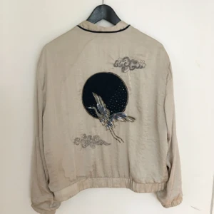  - Säljer den här superfina bomberjackan från Zara då den inte kommit så mkt till användning. Beige/naturvitt silkesliknande material med superfint motiv på ryggen i mörkblå sammet 🌌🌟  Möts upp i sthlm eller skickar mot fraktkostnad :-)) Kolla gärna in mina andra plagg till salu! 💘