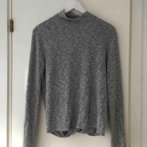  - Grå stickad tröja med öppen rygg från Nelly. Finns ett pyttelitet hål på axeln men annars i bra skick. Fraktar helst!