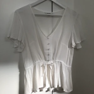 Blus - Blus med knappar och knyt. Aldrig använd. Priset är ink frakt