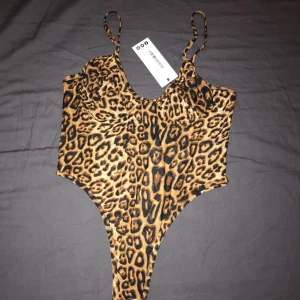 Body - Skitsnyggt leopard mönsrad body från boohoo. Aldrig använd därav att lapparna är kvar. Liten öppen rygg och string där bak. Vid fler bilder så skriv!