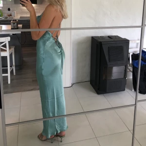 Satinklänning - Blå satinklänning från ASOS storlek 38 (skulle säga att den passar xs-m då man spänner åt den i ryggen). Klänningen är aldrig använd, prislappen är dock borta då jag ändrade mig i sista sekund till en annan klänning, där av kan jag ej returnera den. Vid intresse kan jag skicka fler bilder. Köpt för 400kr 