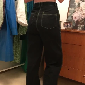 Svarta byxor med gröna sömmar - Fina byxor från junkyard. De är högmidjade och en bra längd på mig som är 173 cm. Väldigt fint skick.